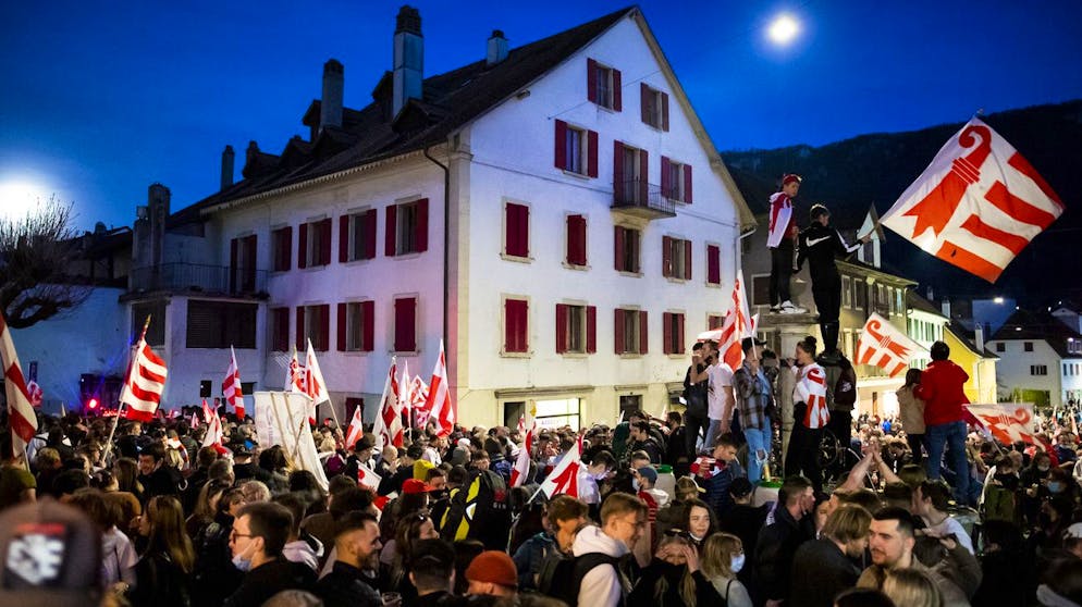 Les pro-jurassiens celebrent le oui devant l' Hotel de Ville ou a ete dresse un drapeau du canton du Jura apres l'annonce du resultat du vote ce dimanche 28 mars 2021 a Moutier. Les citoyens de Moutier doivent decider de l'appartenance cantonale de leur ville et ainsi quitter le canton de Berne pour rejoindre celui du Jura. (KEYSTONE/Jean-Christophe Bott)