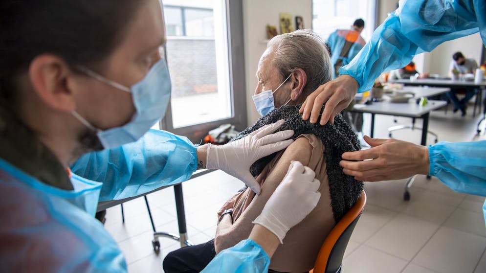 Des membres d'une equipe mobile de vaccination de la protection civile vaudoise, PC, vaccine une homme a l'aide du vaccin Pfizer-BioNTech dans les logements proteges Les Saules, lors du dernier jour de vaccination dans les EMS du Canton de Vaud pendant la pandemie de Coronavirus Covid-19, ce jeudi, 18 mars 2021 a Nyon. (KEYSTONE/Martial Trezzini)