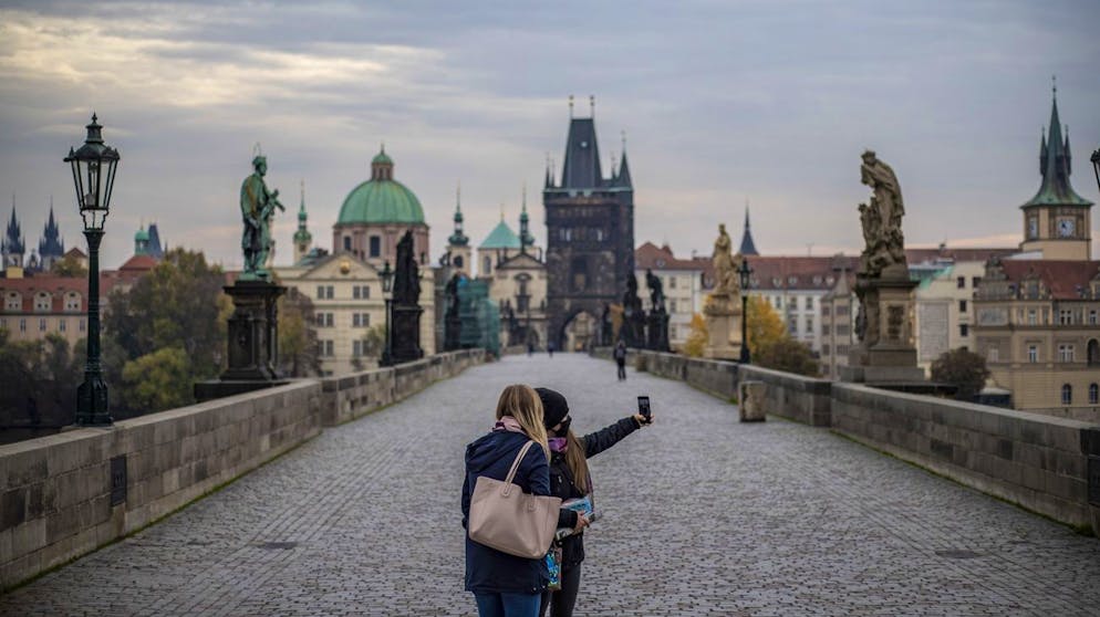 epa08761652 Women wearing a protective face masks take selfie on almost abandoned Charles Bridge in Prague, Czech Republic, 21 October 2020. The Czech Republic recorded a rise in the COVID-19 disease, an increase in newly detected infections exceeding 11,000 in last days, resulting in the government to impose a series of new further restrictive measures from 22 October, with mandatory masks in outside places from 21 October. EPA/MARTIN DIVISEK