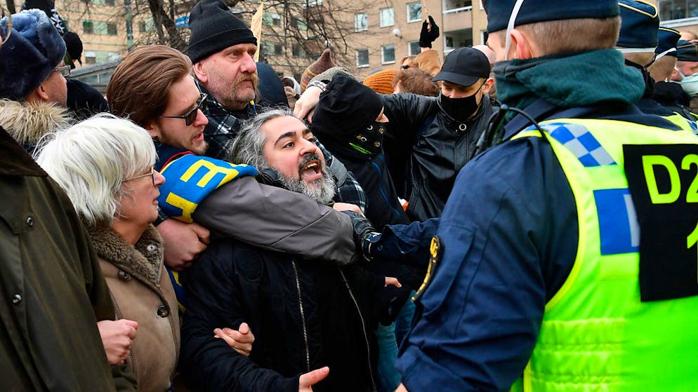 Menschen demonstrieren ohne Mund-Nasen-Schutz gegen die Corona-Beschränkungen des Landes und treffen auf Polizisten. Der Protest wurde von der Polizei wegen fehlender Genehmigung für die öffentliche Versammlung aufgelöst. Foto: Henrik Montgomery/TT NEWS AGENCY/dpa