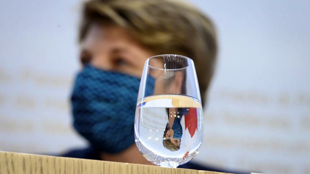 Bundesraetin Viola Amherd, spiegelt sich in einem Glas Wasser, an einer Medienkonferenz zur Armeebotschaft 2021 statt, am Donnerstag, 18. Februar 2021, im Medienzentrum Bundeshaus in Bern. (KEYSTONE/Anthony Anex)