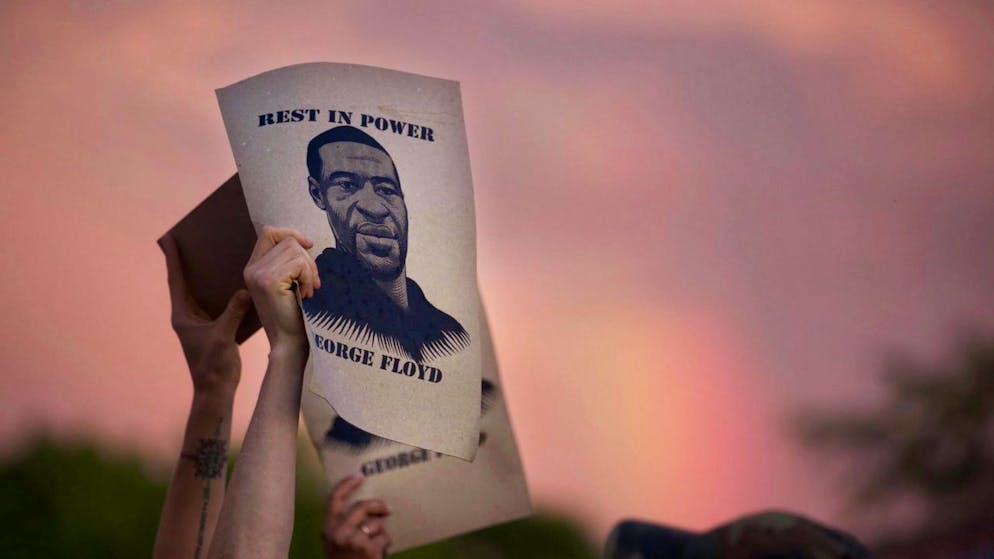 Demonstranten halten während eines Protestes Zettel mit dem Porträt von George Floyd, des in Minneapolis nach einem brutalen Polizeieinsatz gestorbenen Schwarzen, in die Höhe.