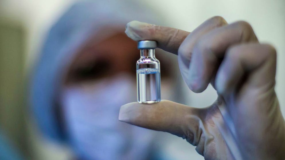 Eine Mitarbeiterin der Fiocruz Foundation zeigt ein Fläschchen des Impfstoffs von AstraZeneca gegen Covid-19. Foto: Bruna Prado/AP/dpa