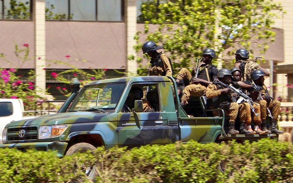 Troops ride in a vehicle near the French Embassy in central Ouagadougou, Burkina Faso, Friday March 2, 2018. Gunfire and explosions rocked Burkina Faso's capital early Friday in what the police said was a suspected attack by Islamic extremists. By midday the gunfire became intermittent and helicopters flew above the French Embassy in Ouagadougou.(AP Photo/ Ludivine Laniepce)