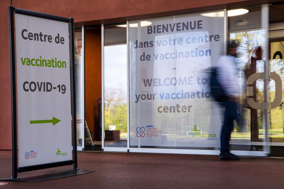 Une personne passe devant l'entree du futur centre de vaccination Covid-19 a Palexpo, ce jeudi 15 avril 2021 a Geneve. Le grand centre sera ouvert 6 jours sur 7, comprendra 150 box individuel pour la vaccination, et pourra vacciner entre 2000 a 4000 personnes par jours selon l'arrivage des doses de vaccin. (KEYSTONE/Martial Trezzini)