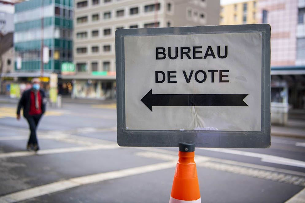 Un panneau indique l'entree du bureau de vote lors du premier tour des elections cantonales neuchateloises le dimanche 18 avril 2021 a La Chaux-de-Fonds. (KEYSTONE/Jean-Christophe Bott)