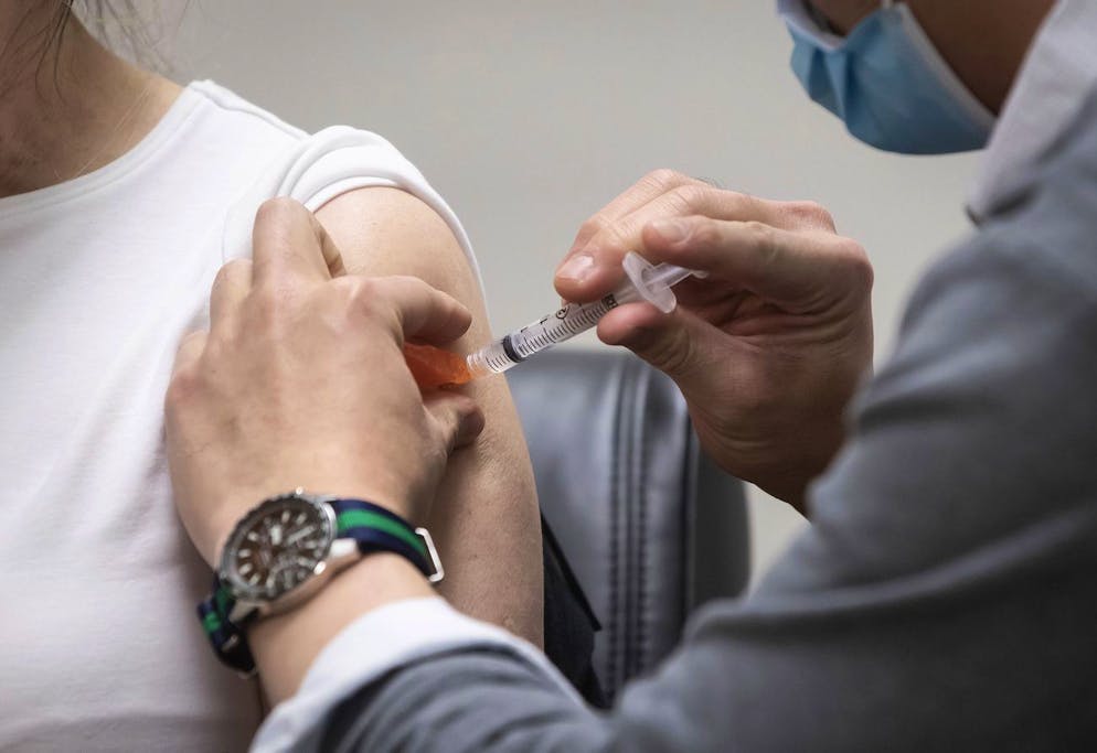 Pharmacist Mario Linaksita administers the AstraZeneca COVID-19 vaccine to Sharon Berringer, 56, at University Pharmacy, in Vancouver, British Columbia, Thursday, April 1, 2021. in Vancouver, British Columbia, Thursday, April 1, 2021. Residents between the ages of 55 and 65 in the Vancouver Coastal Health and Fraser Health regions were able to book appointments to receive the AstraZeneca vaccine after British Columbia enlisted 150 pharmacies to distribute 13,500 doses. B.C. Health Minister Adrian Dix said 43,000 additional doses are expected to be sent to pharmacies later this week. (Darryl Dyck/The Canadian Press via AP)