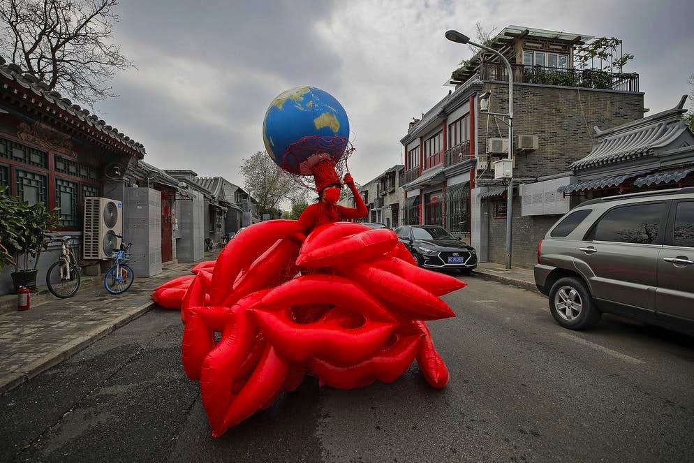 Coraggio da vendere!. Strana creatura: Kong Ning, artista e attivista ambientalista cinese, mostra per le strade della città la sua ultima collezione di abiti ispirati al tema «Abbraccia la terra» in occasione della Giornata della Terra a Pechino. (22 aprile 2021)