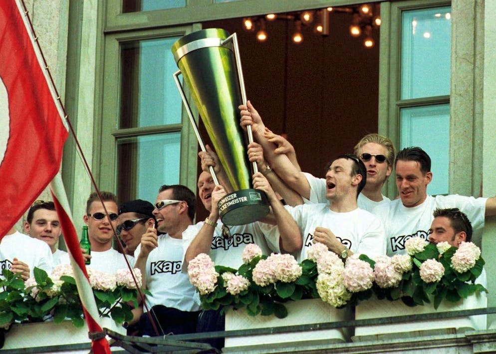 Auf der Piazza Riforma in Lugano wurde der neue Schweizermeister der HC Lugano von den vielen Fans am 9. April 1999 gefeiert. Grosser Jubel als Captain Peter Andersson (links) und Gian Marco Crameri mit dem Meisterpokal auf Ratshaus Terasse erschienen. (KEYSTONE/Karl Mathis)