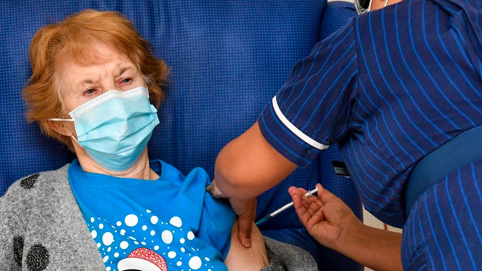 ARCHIV – Die 90-jährige Margaret Keenan (l) war die Erste in Grossbritannien: Im Universitätskrankenhaus Coventry bekam sie im vergangenen Dezember ihre erste Dose mit dem Impfstoff gegen das Coronavirus. Foto: Jacob King/PA Wire/dpa