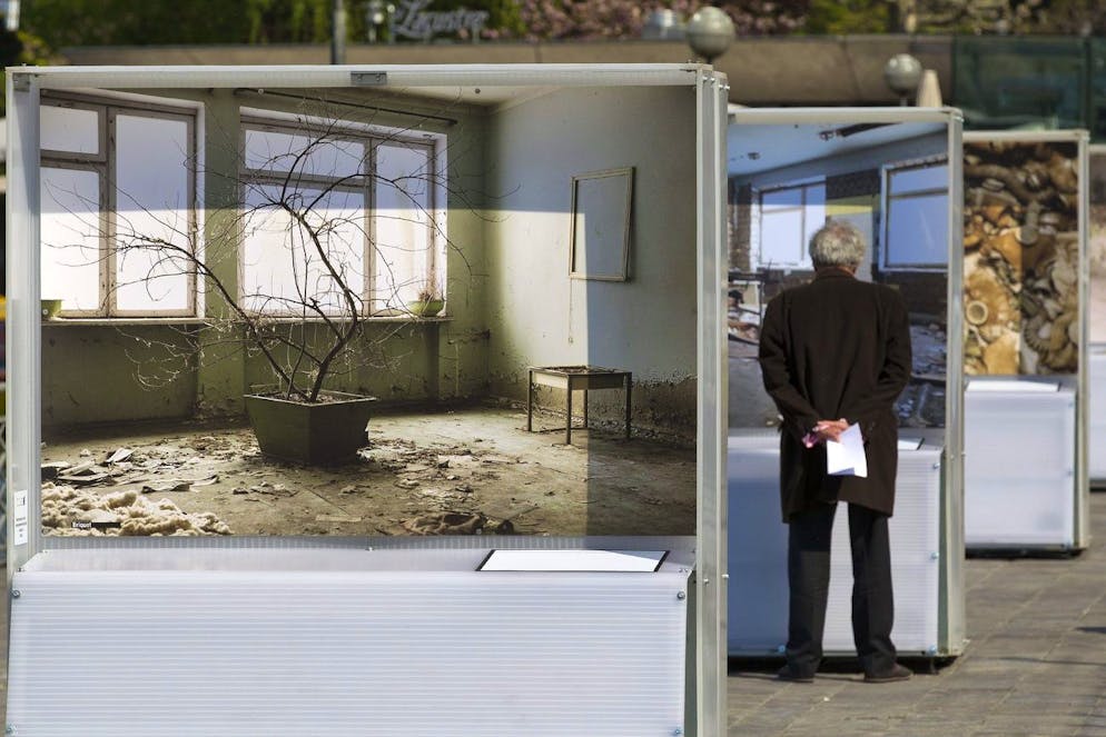 A man looks a giant picture of the open air exhibition titled