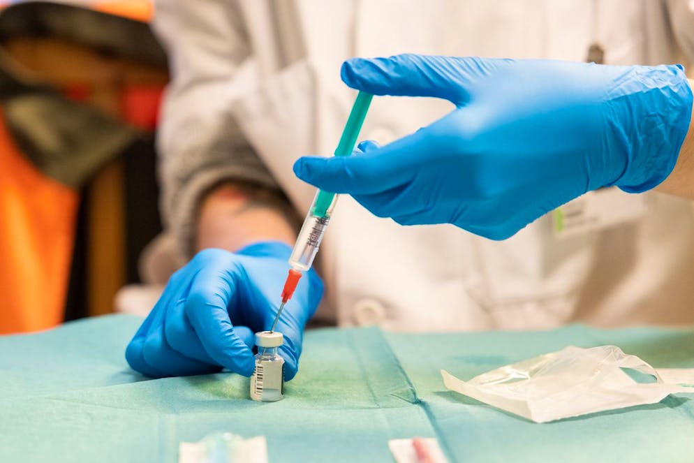Une femme prepare une seringue du vaccin Pfizer-BioNTech dans les locaux de la Fondation Pre Pariset (Etablissements Medico-Sociaux, EMS) avant qu'une equipe mobile de vaccination de la protection civile vaudoise, PC, vaccine pendant la pandemie de Coronavirus (Covid-19), ce vendredi, 22 janvier 2021 a Lausanne. (KEYSTONE/Cyril Zingaro)