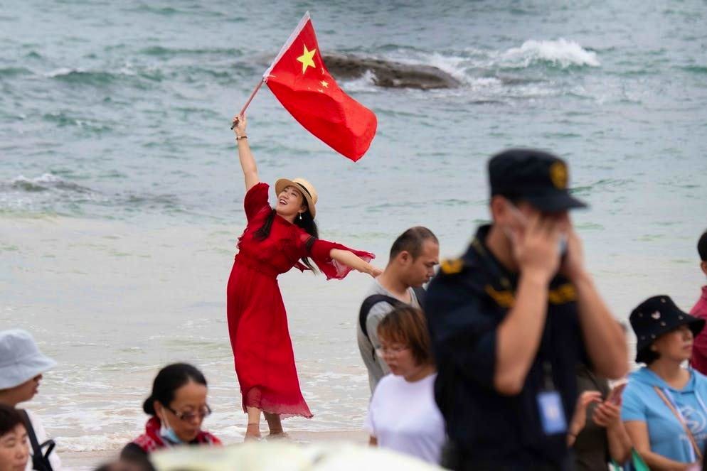 Coraggio da vendere!. Orgogliosa del suo paese... Una donna sventola la bandiera cinese durante un raduno per osservare il lancio del modulo centrale Tianhe («Armonia celeste»), azionato da un razzo Lunga Marcia 5B, dal centro di lancio di Wenchang. La Cina ha lanciato il primo dei tre elementi della sua stazione spaziale, la «CSS», la cui costruzione richiederà fino alla fine del 2022 una decina di missioni. (29 aprile 2021)