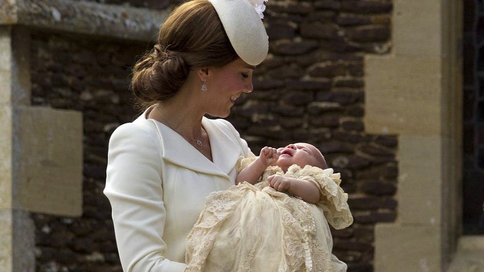 Britain's Kate the Duchess of Cambridge carries Princess Charlotte after taking her out of a pram as they arrive for Charlotte's Christening at St. Mary Magdalene Church in Sandringham, England, Sunday, July 5, 2015. (AP Photo/Matt Dunham, Pool)