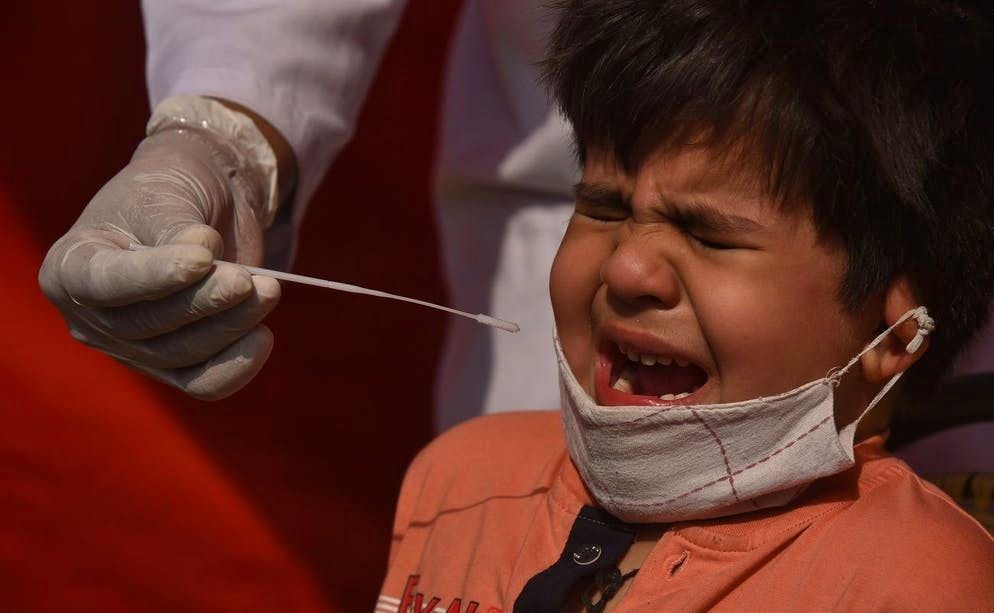 Coraggio da vendere!. Questo bambino indiano sta facendo un test poiché presenta sintomi: la pandemia di coronavirus sta infuriando in India. Il numero di morti ha superato i 200.000 mercoledì 28 aprile, con più di 3.000 decessi segnalati per la prima volta in 24 ore, secondo i dati ufficiali. (29 aprile 2021)