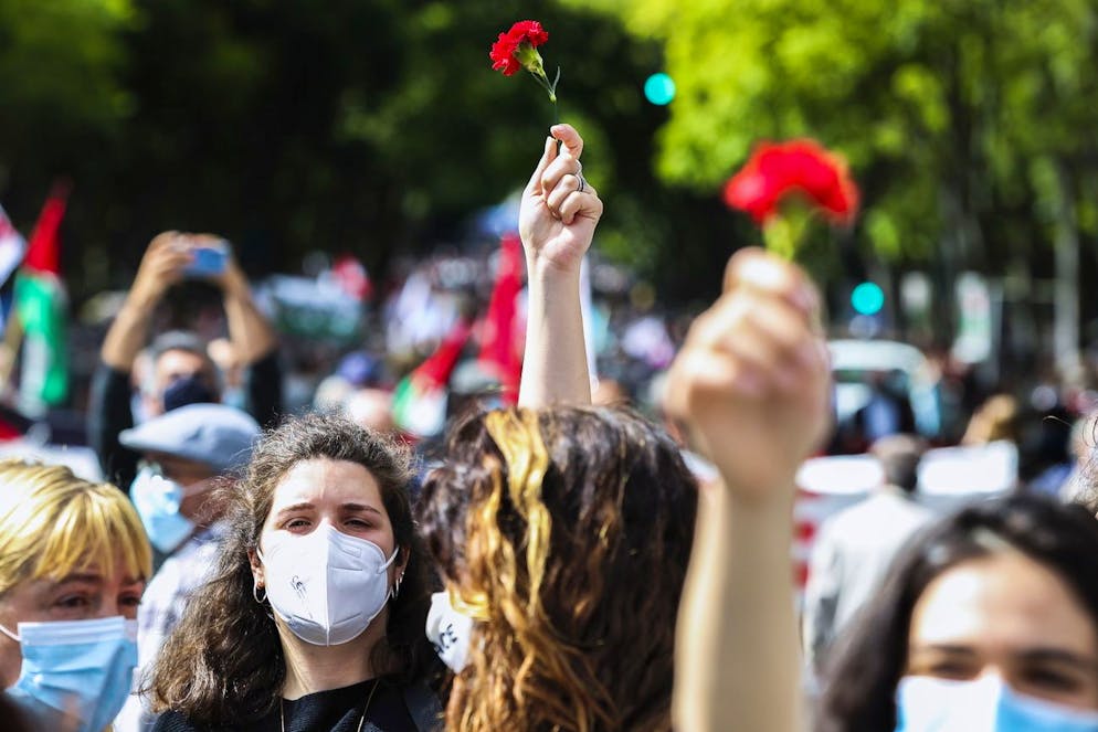 Des gens tiennent des fleurs d'oeillets rouges lors d'une manifestation à l'occasion du 47e anniversaire de la révolution du 25 avril au Portugal