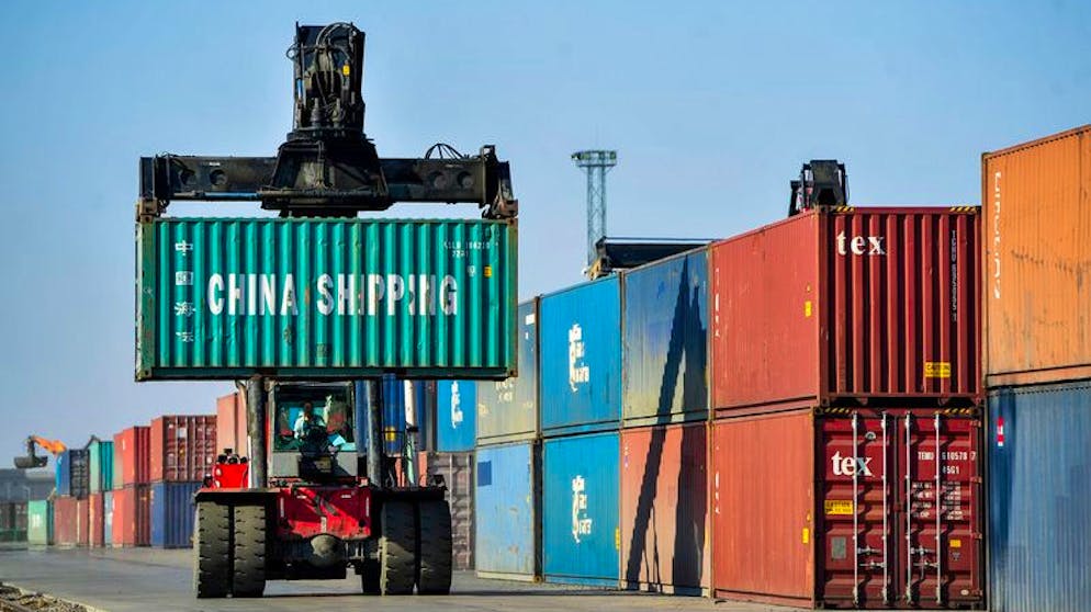 ARCHIV - 11.04.2020, China, Erenhot: Ein Mann rangiert Container für die Weiterverladung in einer Logistikstation. (zu dpa
