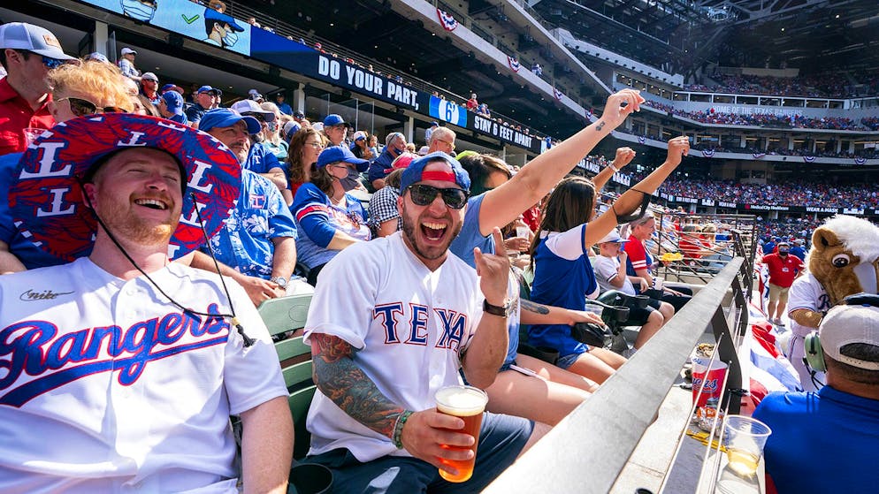 Texas Rangers fans Cameron Leverett, left, and Anthony Sosa celebrate during the fourth inning of a baseball game against the Toronto Blue Jays Monday, April 5, 2021, in Arlington, Texas. (AP Photo/Jeffrey McWhorter)