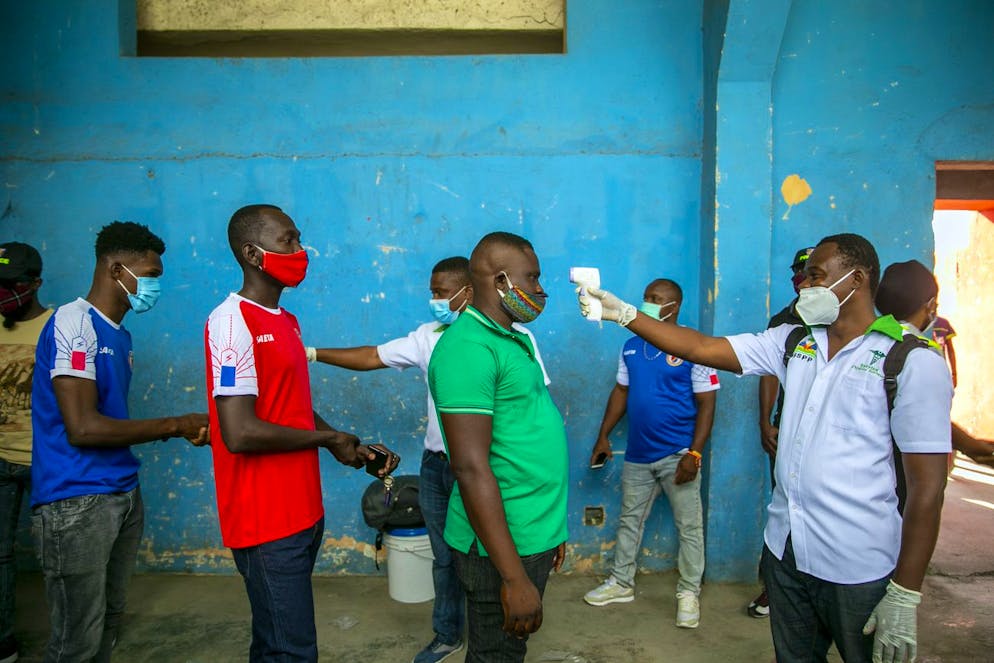 Health ministry workers check the temperature of mask-wearing fans as a precaution against the spread of the new coronavirus, before entering the stadium prior to the start of the CONCACAF World Cup qualifying soccer match between Haiti and Belize in Port-au-prince, Haiti, Thursday, March 25, 2021. ( AP Photo/Dieu Nalio Chery)