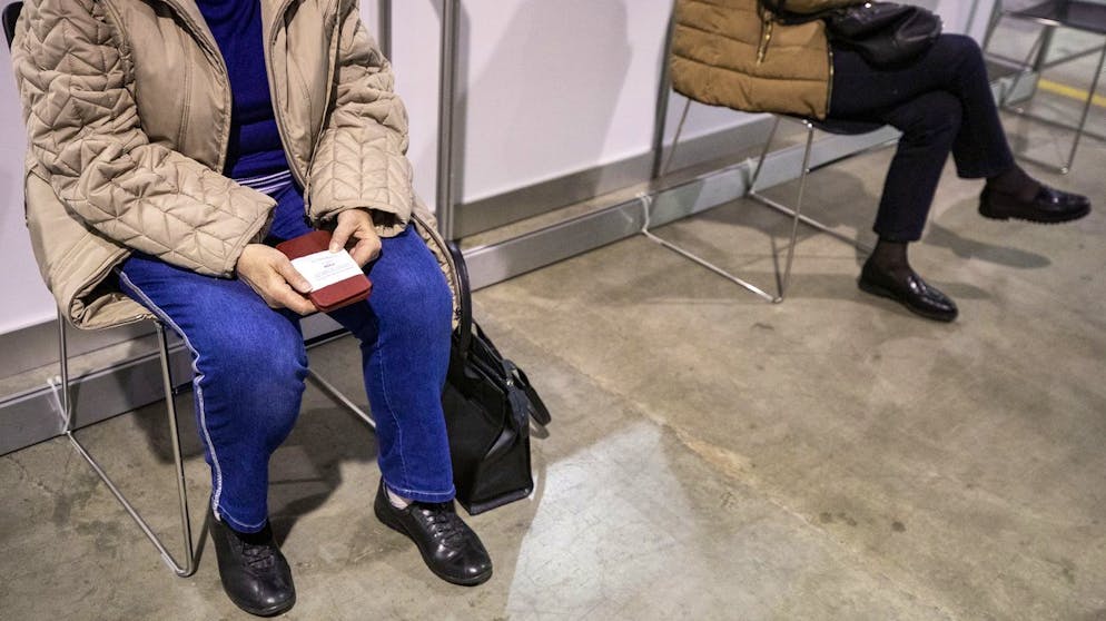 Eine Frau haelt ein Ticket mit einer Nummer in den Haenden fuer ihre Impfung, im groessten Impfzentrum des Kantons Zuerich, dem Covid-19-Impfzentrum Messe Zuerich, am Dienstag, 6. April 2021. Das Impfzentrum nimmt am 6. April seinen Betrieb auf und pro Tag koennen auf 30 Impfstrassen bis zu 4000 Personen geimpft werden. (KEYSTONE/Alexandra Wey)