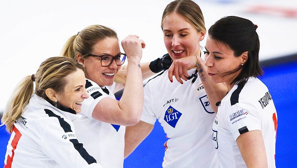 Switzerland skip Silvana Tirinzoni, left, celebrates with, from second from left to right, fourth Alina Paetz, lead Melanie Barbezat and second Esther Neuenschwander after defeating Russia in the final at the women's world curling championship in Calgary, Alberta, Sunday, May 9, 2021. (Jeff McIntosh/The Canadian Press via AP)