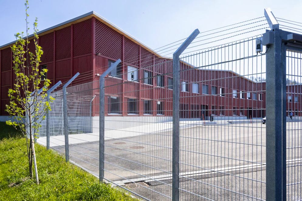 Zaeune saeumen den Erweiterungsbau des Vollzugszentrum Bachtel (VZB), einer kantonalen Institution in der Straffaellige ihre Freiheits- und Ersatzfreiheitsstrafen im offenen Vollzug verbuessen, anlaesslich der Einweihung der Anlage, aufgenommen am Freitag, 23. April 2021 in Hinwil. Die neue Anlage kann 94 Insassen aufnehmen und 50 Mitarbeitende halten den Betrieb aufrecht.(KEYSTONE/Ennio Leanza)