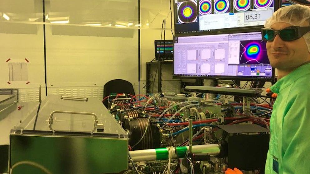 HANDOUT - 25.05.2021, ---: Clemens Herkommer, Entwickler, vor dem Laser im Labor. Können Laser Blitzeinschläge bei sensiblen Einrichtungen wie Atomkraftwerken oder Flughäfen verhindern? Der Genfer Physiker Jean-Pierre Wolf glaubt: ja. In einem Feldversuch wird in der Schweiz eine in Deutschland entwickelte neun Meter lange Blitzkanone getestet. (zu dpa «Blitzkanone mit deutschen Laser - Pilotprojekt in der Schweiz») Foto: TRUMPF/dpa - ACHTUNG: Nur zur redaktionellen Verwendung und nur mit vollständiger Nennung des vorstehenden Credits +++ dpa-Bildfunk +++