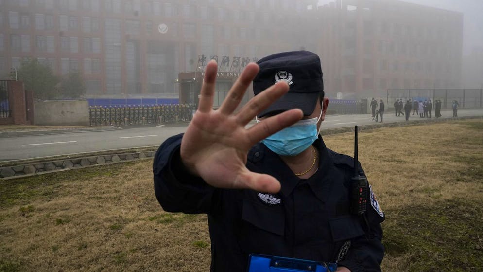 A security person moves journalists away from the Wuhan Institute of Virology after a World Health Organization team arrived for a field visit in Wuhan in China's Hubei province on Wednesday, Feb. 3, 2021. The WHO team is investigating the origins of the coronavirus pandemic has visited two disease control centers in the province. (AP Photo/Ng Han Guan)