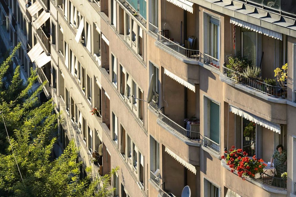 Une femme arrange ses geraniums sur son balcon d'un immeuble a la rue St.-Martin lors d'une manifestation