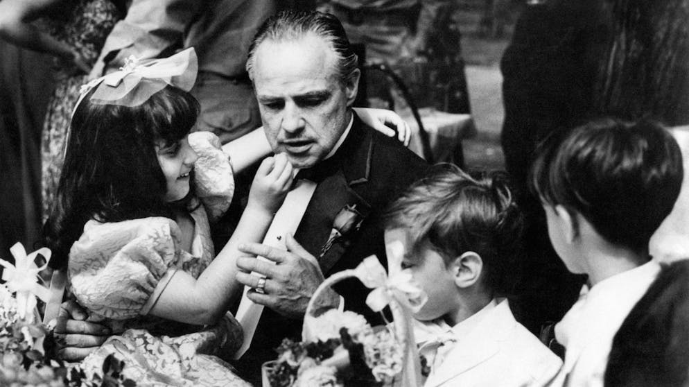 American actor Marlon Brando, as Don Vito Corleone, with some children at her daughter's wedding reception in the movie The Godfather by Francis Ford Coppola. 1972. (Photo by Mondadori via Getty Images)