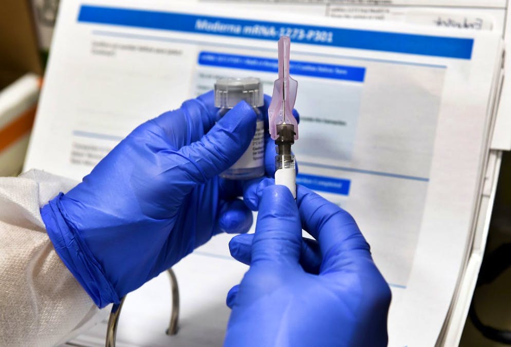 FILE - In this July 27, 2020, file photo, nurse Kathe Olmstead prepares a shot that is part of a possible COVID-19 vaccine, developed by the National Institutes of Health and Moderna Inc., in Binghamton, N.Y. Moderna Inc. says it will ask U.S. and European regulators to allow emergency use of its COVID-19 vaccine as new study results confirm the shots offer strong protection. (AP Photo/Hans Pennink, File)