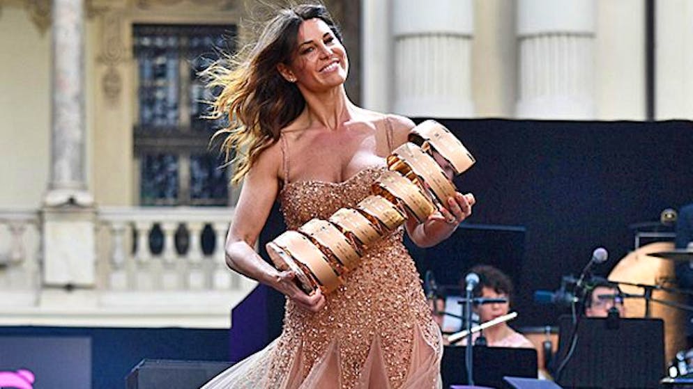 TV-Host Barbara Pedrotti präsentiert die Siegertrophäe.