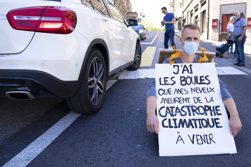 Climate activist of Extinction Rebellion (XR) sit down with a sign