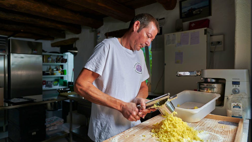 Gnocchi Produktion. DIe Kartoffeln werden gekocht, geschält, in der Spätzles Presse gepresst und mit Mehl zusammen geknetet, in Wurstform gewallt und je nach Kunde, kleiner oder grösser geschnitten. Für den Kindergarten macht Olaf die kleinsten Gnocchi. Bei Olaf Baumann, Pastificio Artigianale, bei der Produktion von Teigwaren, Hamburger, Ravioli und Gnocchi in Breno / Tessin. Eine Geschichte der Schweizer Berghilfe im Jahr 2020.