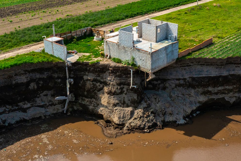 SANTA MARIA ZACATEPEC, MEXICO - JUNE 09: Aerial view of a giant sinkhole on June 09, 2021 in Santa María Zacatepec, Mexico. The giant sinkhole is located 20 kilometers northwest from the capital city Puebla, the hole now measures 110 meters across its widest point, covering around 11,000 square meters and damaging a house built near the place where it appeared. Farmers of the surroundings have been affected since they are not allowed to enter their fields due to the warning perimeter set up by the authorities. (Photo by Hector Vivas/Getty Images)