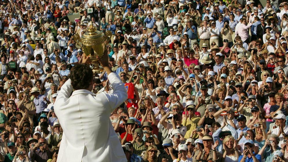 Switzerland's Roger Federer holds up the trophy to show the crowd, after defeating Rafael Nadal to win his fifth consecutive Men's Singles Championship on the Centre Court at Wimbledon, Sunday July 8, 2007.(AP Photo/Anja Niedringhaus) ** EDITORIAL USE ONLY **