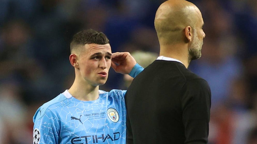 epa09235975 Phil Foden (L) and manager Josep Guardiola of Manchester City react after the UEFA Champions League final between Manchester City and Chelsea FC in Porto, Portugal, 29 May 2021. EPA/Carl Recine / POOL