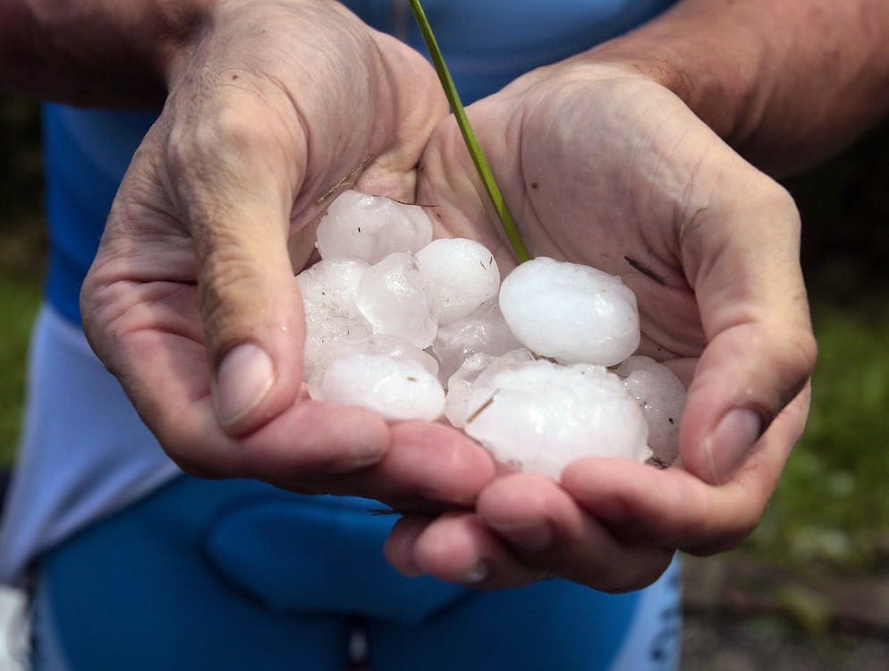 Swiss cyclist Marcus Zberg holds hailstones in his hands after a hailstorm during the 6th stage of the 71st Tour of Switzerland cycling race over 191 km from Giubiasco to Crans-Montana, near Gnosca, Switzerland, Thursday, June 21, 2007. Due to he hailstorm, the race was stopped temporarily and a new start took place in Ullrichen later on. (KEYSTONE/Eddy Risch)