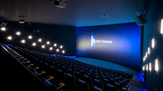 Kinosaal mit blauer Ambientebeleuchtung und dem „blue Cinema“-Logo auf der Leinwand.