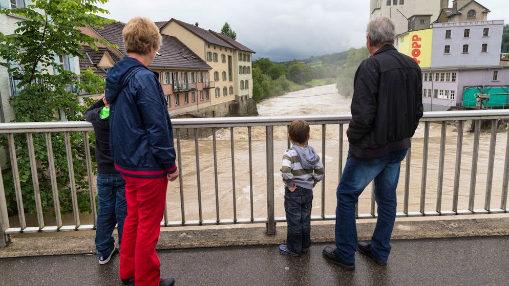 Eine Familie betrachtet die hochwasserfuehrende Sitter in Bischofszell-Nord, am Dienstag, 22. Juli 2014. In den Kantonen St. Gallen, Thurgau und Appenzell Ausserrhoden meldeten die Polizeien am Dienstagvormittag mit Wasser vollgelaufene Keller. In Bischofszell TG hatte die Thur die erste Hochwassermarke erreicht. Die Feuerwehr beobachtete die Situation, hiess es auf Anfrage der SDA. (KEYSTONE/Arno Balzarini)