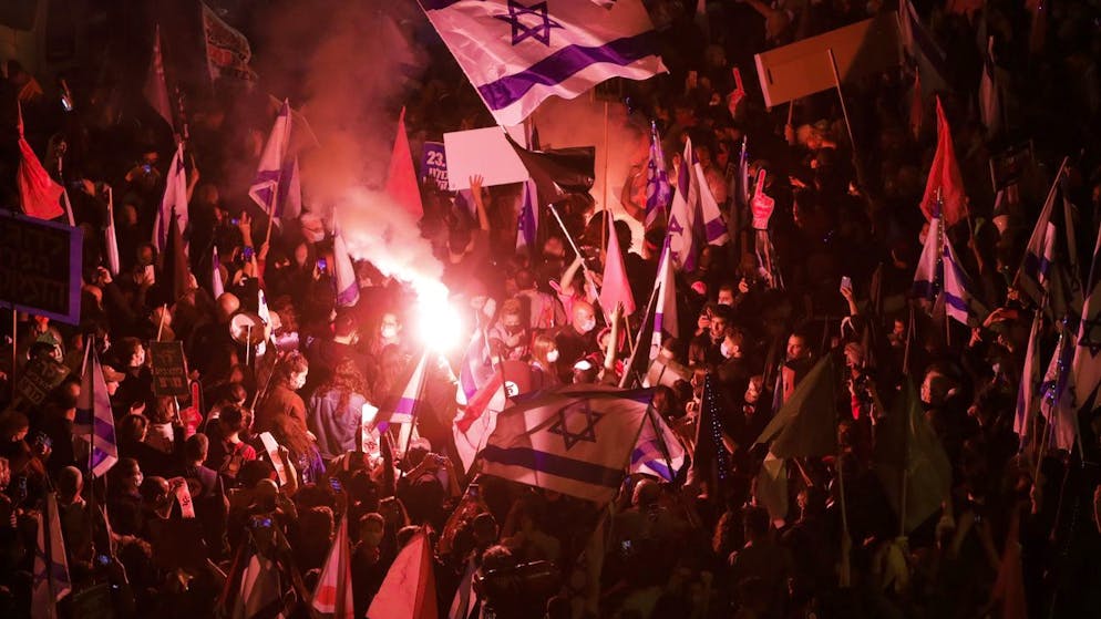 Thousands of protesters chant slogans and hold signs during a protest against Israel's Prime Minister Benjamin Netanyahu outside his residence in Jerusalem, Saturday, March. 20, 2021. The weekly protests against Netanyahu's corruption charges and his handling of the pandemic have persisted since summer, but tonight's gathering is the last before Israel will be holding its fourth election in two years on March 23. (AP Photo/Sebastian Scheiner)