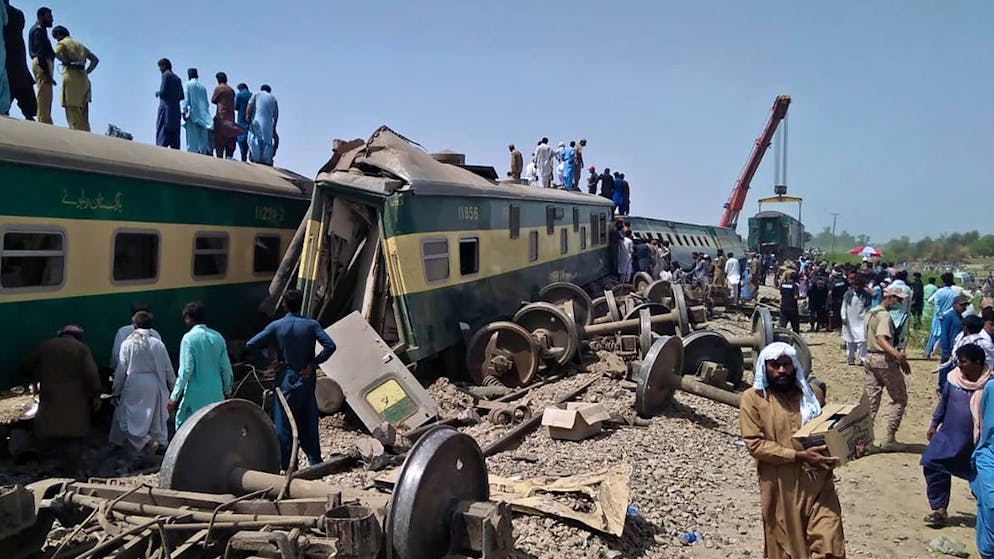 Soldiers and volunteers work at the site of a train collision in Ghotki district in southern Pakistan, Monday, June 7, 2021. Two express trains collided in southern Pakistan early Monday, killing dozens of passengers, authorities said, as rescuers and villagers worked to pull injured people and more bodies from the wreckage. (AP Photo/Waleed Saddique)
