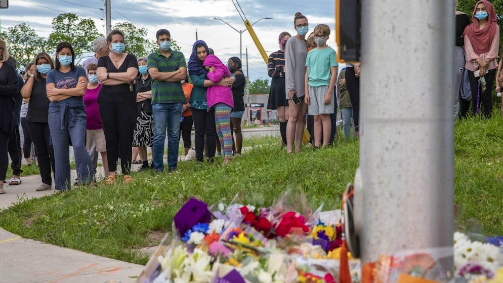 People attend a memorial at the location where a family of five was hit by a driver, in London, Ontario, Monday, June 7, 2021. Four of the members of the family died and one is in critical condition. A 20-year-old male has been charged with four counts of first degree murder and count of attempted murder in connection with the crime. (Brett Gundlock/The Canadian Press via AP)