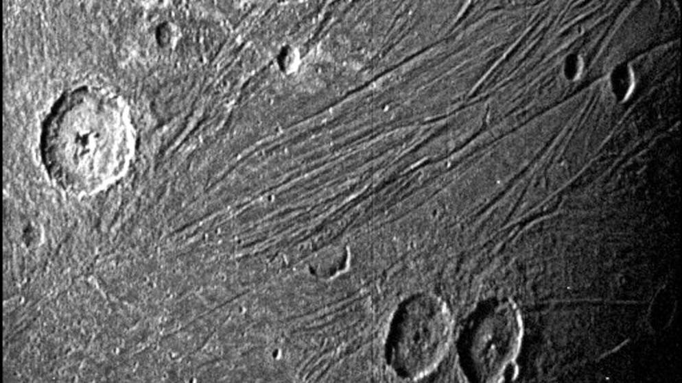 08.06.2021, ---, Weltraum: Dieses von der NASA zur Verfügung gestellte Bild vom 7. Juni 2021 zeigt die dunkle Seite des Jupiter-Monds Ganymed, während die Raumsonde Juno vorbeifliegt.