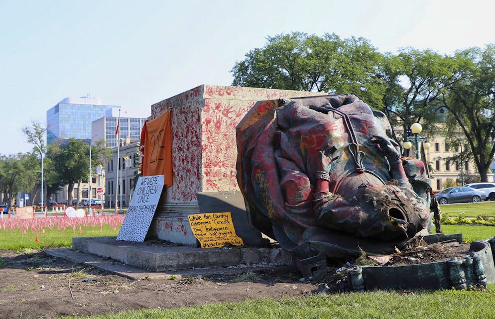 A headless statue of Queen Victoria is seen overturned and vandalized at the provincial legislature in Winnipeg, Friday, July 2, 2021. Her statue and a statue of Queen Elizabeth II were toppled on Canada Day during demonstrations concerning Indigenous children who died at residential schools. (Kelly Geraldine Malone/The Canadian Press via AP)