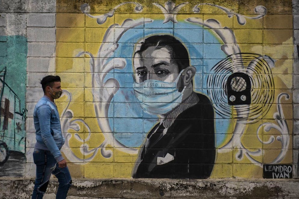 Le légendaire chanteur de tango Carlos Gardel est représenté sur une fresque de rue utilisant un masque facial au milieu de la pandémie de coronavirus à Montevideo, Uruguay, le jeudi 24 juin 2021.