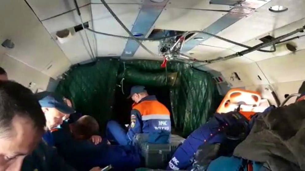 epa09325206 A handout photo made available b the press service of the Russian Ministry for Civil Defence, Emergencies and Elimination of Consequences of Natural Disasters (EMERCOM of Russia) shows a group of rescuers who are involved in the search of an An-26 plane, on board of a Mi-8 helicopter, in Kamchatka, Russia, 06 July 2021. An An-26 plane with 28 people on board en route from Petropavlovsk-Kamchatsky to Palana was lost about 10 minutes before landing. EPA/EMERCOM OF RUSSIA PRESS SERVICE / HANDOUT MANDATORY CREDIT/BEST QUALITY AVAILABLE/ HANDOUT EDITORIAL USE ONLY/NO SALES