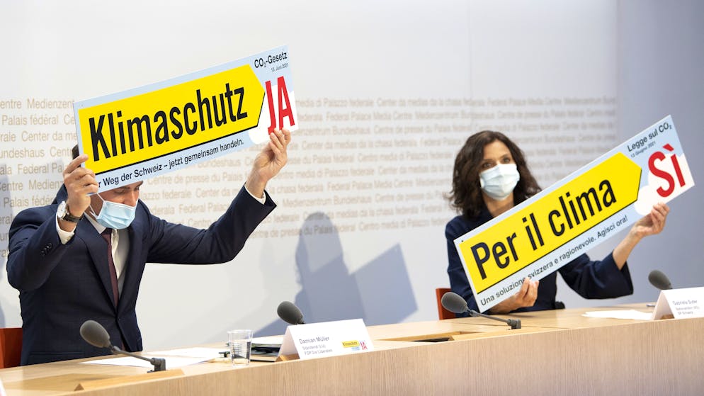 Staenderat Damian Mueller, FDP-LU, links, und Nationalraetin Gabriela Suter, SP-AG, vom Ja Komitee zum CO2 Gesetz praesentieren ein Plakat und sprechen an einer Medienkonferenz, am Dienstag, 27. April 2021, in Bern. (KEYSTONE/Peter Schneider)