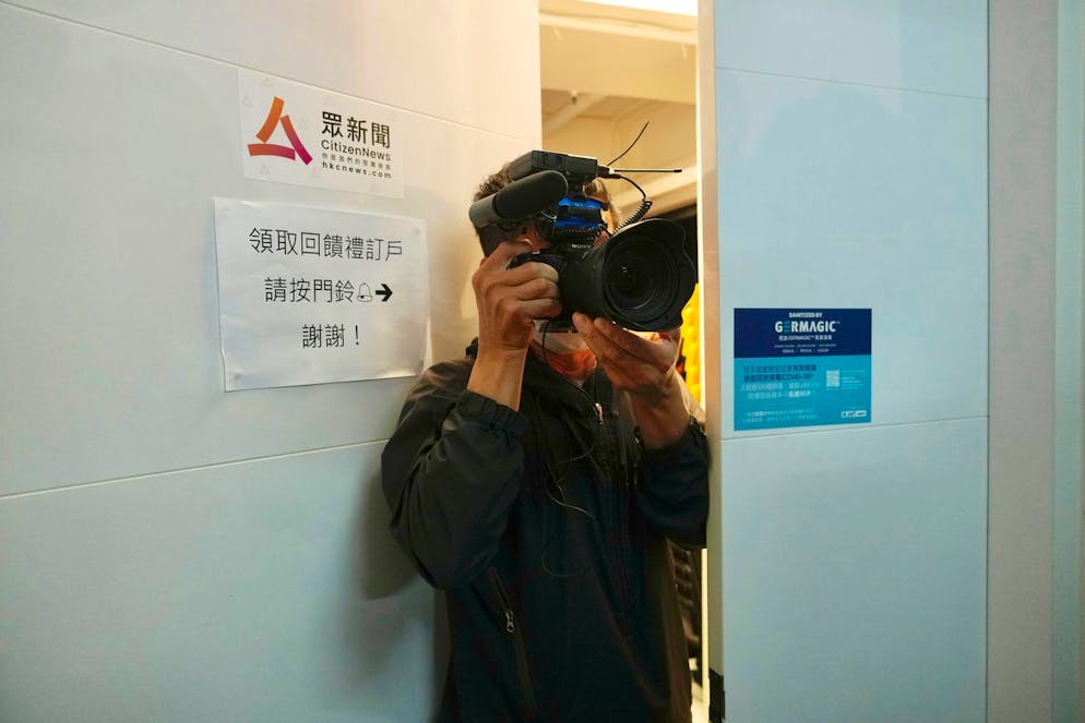 Un photographe de Citizen News prend des photos à l'entrée de son bureau à Hong Kong le lundi 3 janvier 2022. Le site d'information en ligne de Hong Kong a annoncé dimanche qu'il cesserait ses activités en raison de la détérioration des libertés de la presse, quelques jours après la descente et l'arrestation de la police.