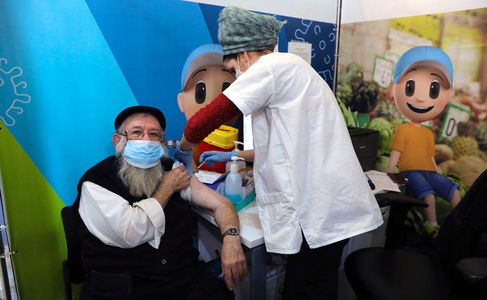 epa09664838 A nurse injects a 73-year-old man with the fourth dose of a COVID-19 vaccine at a vaccination center in Jerusalem, Israel, 03 January 2022. Israel has approved the administration of the fourth dose of COVID-19 vaccine for people over the age of 60 as well as medical staff amid an increase of infections and concers over the 'Omicron' variant of SARS-CoV-2, the virus that causes COVID-19. The fourth dose will be offered on the condition that four months have passed since the date of receiving the third one. EPA/ABIR SULTAN